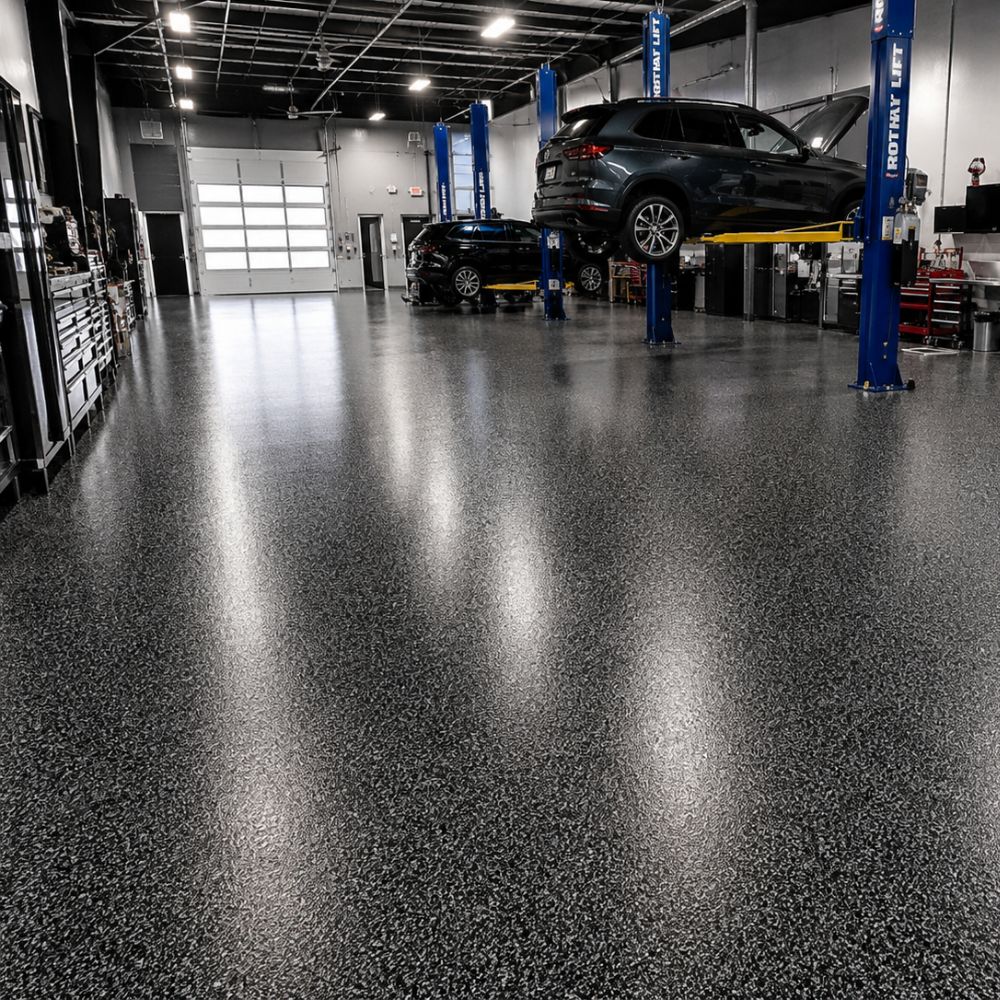 Automotive repair shop interior with a car on a lift and tool benches along the walls, bright overhead lights