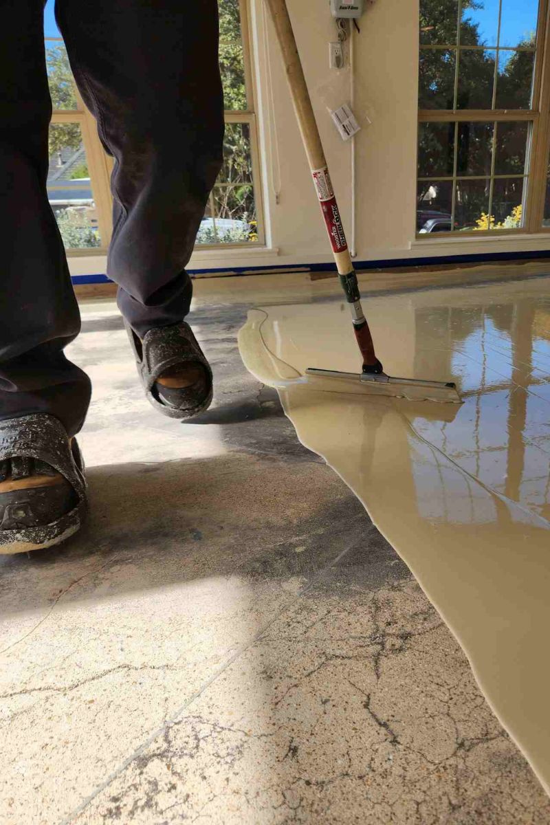 Worker Applying Garage Floor Paint with a Squeegee. - Expert Garage Floor Painting - Expert Garage Floor Painting