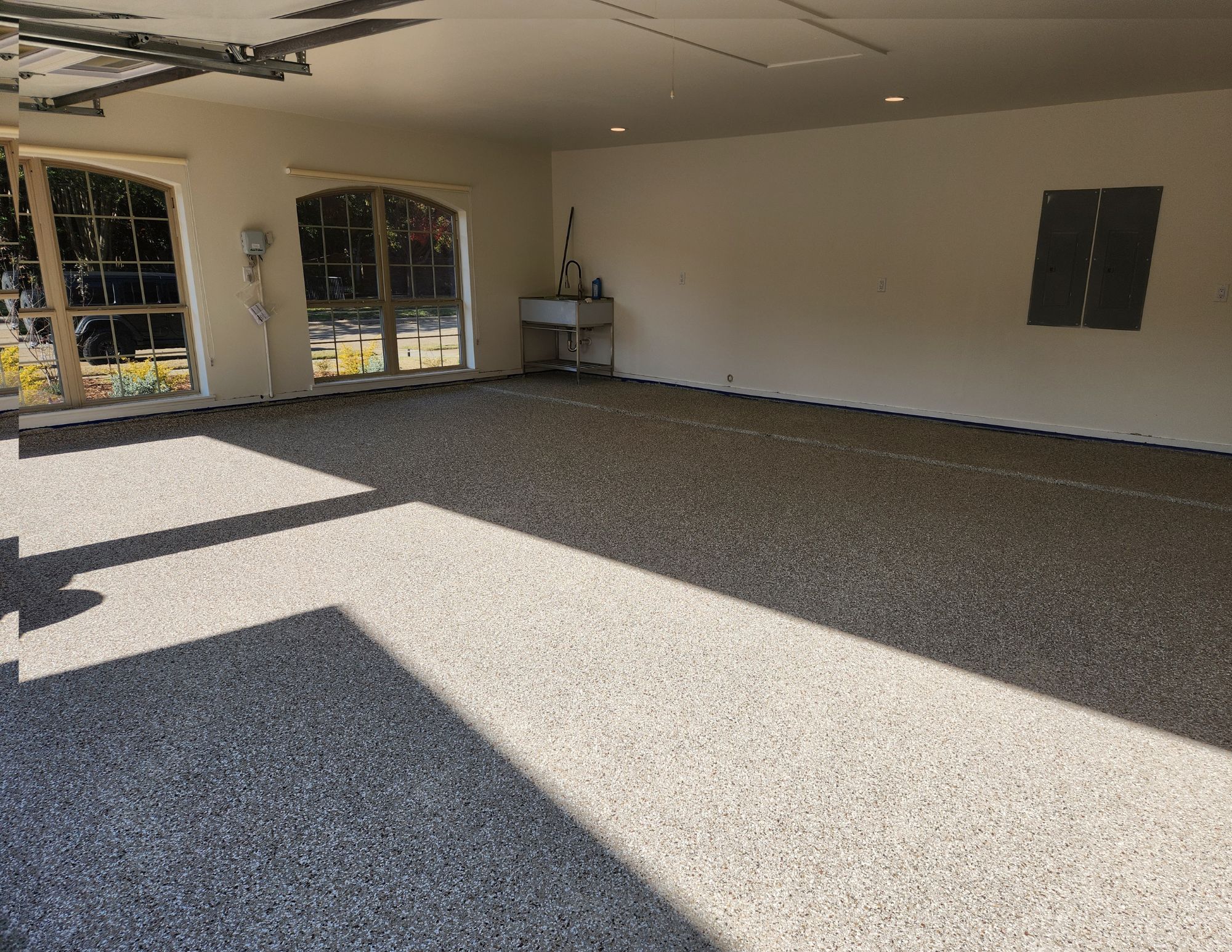 a Garage with a Newly Applied Polyaspartic Floor Coating by Mygaragefloors.com, Featuring a Seamless and Durable Finish. - Completed Garage Floor Coating