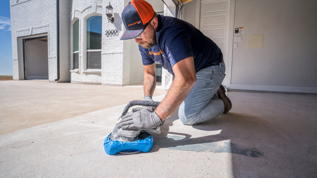 Diamond grinding a garage slab down to open concrete before the polyaspartic base coat