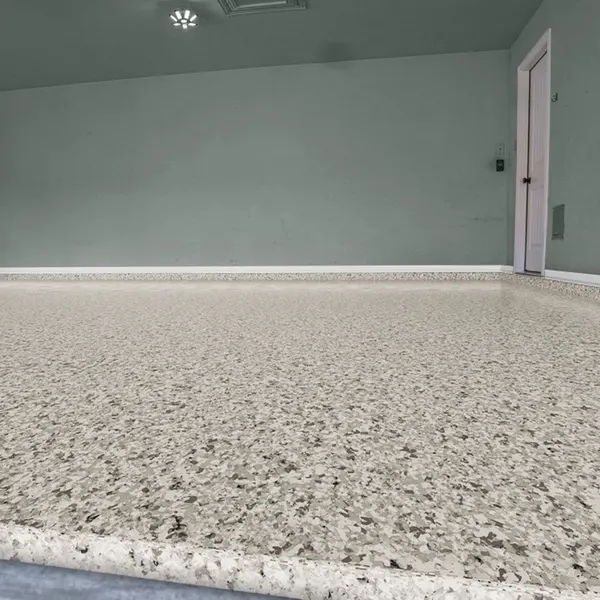 The same garage after coating, with a Snowfall white and tan full flake polyaspartic floor by MyGarageFloors.com