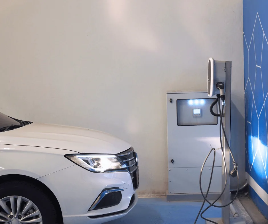 A car parked beside an EV charging station in a home garage