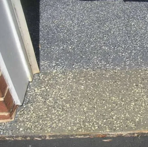 Close up of a flake floor meeting the rubber seal at the garage door threshold