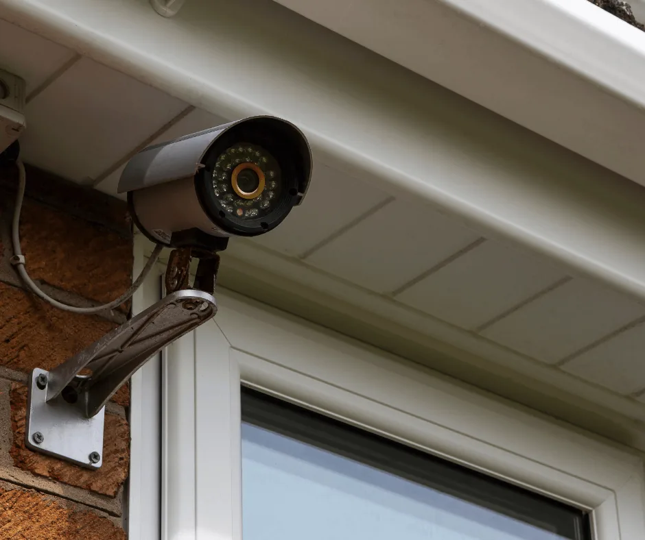 A security camera mounted under the eave above a garage